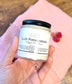 Close-up of Eden Body Care Lush Pomegranate whipped body mousse jar held in hand against a soft pink background.