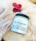 Eden Body Care Lush Pomegranate whipped body mousse jar styled on soft cream fabric with dried pink and purple flowers.