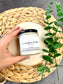 Eden Body Care Eucalyptus & Mint body mousse jar held in hand on a natural wood slice beside green leaves