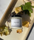 Eden Body Care Lavender body mousse jar styled on a white towel in natural sunlight with green leaves around it