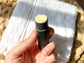 Close-up of an open Eden Body Care lip balm tube held in hand, showing the pale natural balm inside.