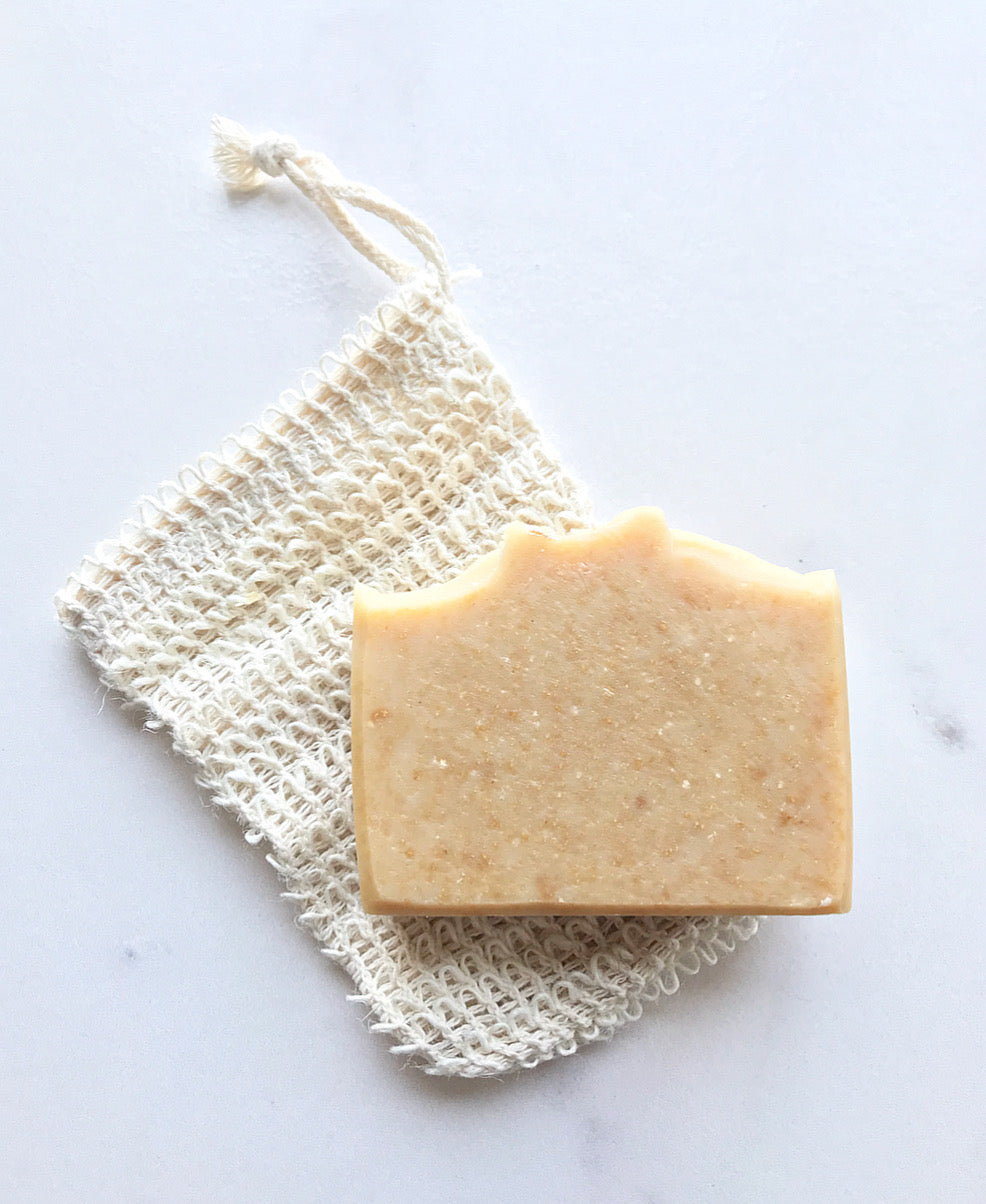 one bar of oatmeal honey soap laid on top of a soap jacket