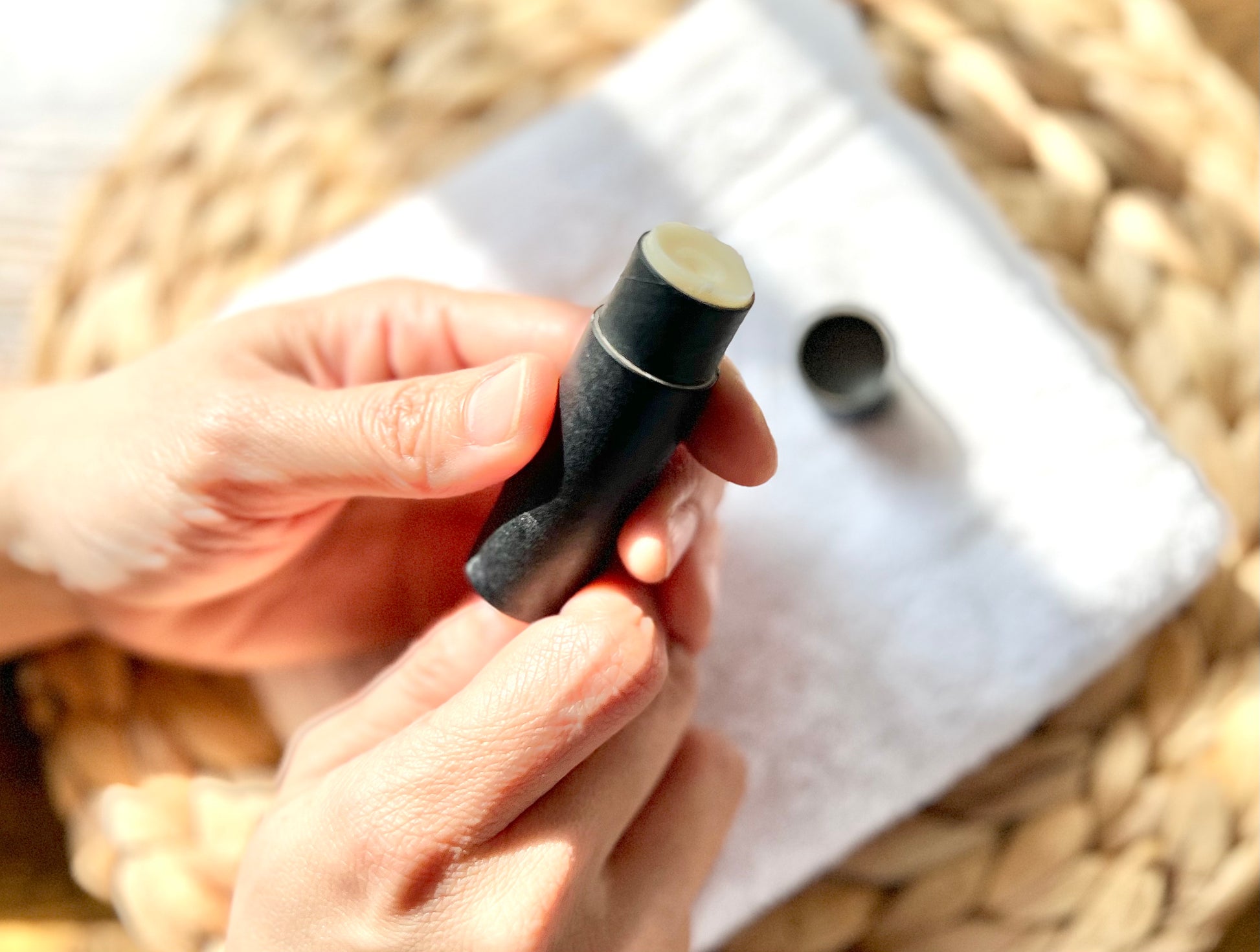 Open Eden Body Care peppermint lip balm tube held in hand, showing the natural balm inside.
