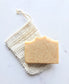 Handmade soap bar resting on a natural sisal soap saver bag, showing an easy way to store and lather the soap.